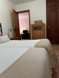 a bedroom with two beds and a desk and a mirror at Remoña 2 in Espinama
