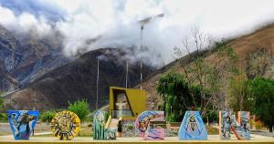 a group of signs in front of a mountain at Hospedaje ESMERALDA in Volcán