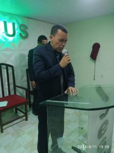 a man standing at a table with a microphone at Borges in Cabo de Santo Agostinho