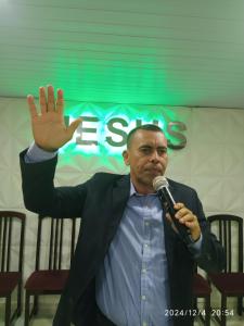 a man holding his hand up in front of a microphone at Borges in Cabo de Santo Agostinho