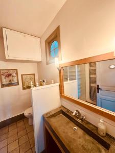 a bathroom with a sink and a toilet and a mirror at Le trente trois in Uzès +60 photos