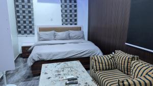 a bedroom with a bed and a couch and a table at Hen-Cap Apartment Services in Agege +7 photos