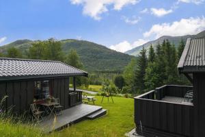 a small cabin with a deck and a picnic table at Kvila in Surnadal
