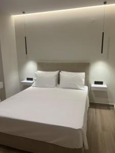 ein großes Bett mit weißen Laken und Kissen in der Unterkunft GreDa in Malia + 15 Fotos