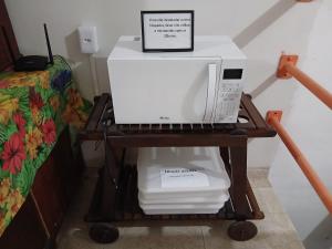 a microwave sitting on a cart next to a bed at Suite Vista Mar in Salvador