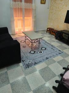 a living room with a table on a tiled floor at Pas de nom in Bouzareah