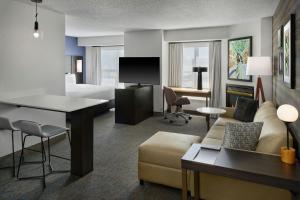 a hotel suite with a living room and a bedroom at Residence Inn by Marriott Flint Grand Blanc in Flint
