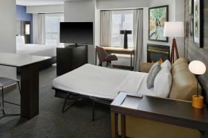 a hotel room with a bed and a couch at Residence Inn by Marriott Flint Grand Blanc in Flint