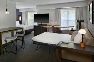 a hotel room with a bed and a living room at Residence Inn by Marriott Flint Grand Blanc in Flint +24 photos