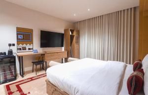 a bedroom with a bed and a desk with a television at نخله للوحدات السكنية 2 in Medina