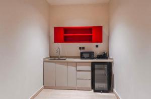 a small kitchen with a sink and red cabinets at نخله للوحدات السكنية 2 in Medina +20 photos