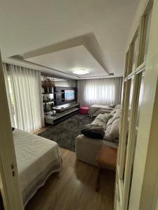 a bedroom with two beds and a flat screen tv at Casa Garavaglia in Bento Gonçalves +25 photos
