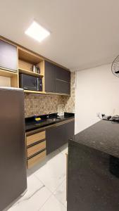 a kitchen with wooden cabinets and a black counter top at 204 Eco Paradise Cumbuco in Caucaia +13 photos