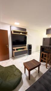 a living room with a couch and a tv and a table at 204 Eco Paradise Cumbuco in Caucaia