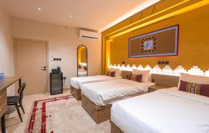 a hotel room with three beds and a television at نخله للوحدات السكنية 2 in Medina