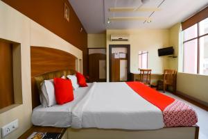 a bedroom with a large bed with red pillows at Hotel Samar Palace Near Sodala Vivek Vihar Metro Station in Jaipur