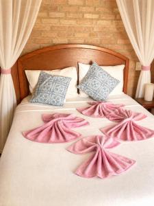 a bedroom with a bed with pink sheets and pillows at Refúgio mar aberto BA in Alcobaça