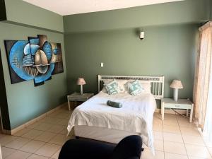a bedroom with a bed and a painting on the wall at Postmasburg hotel in Postmasburg