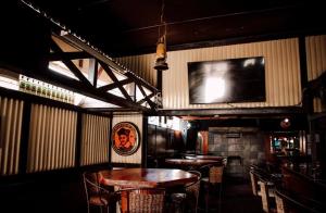 a bar with tables and chairs and a tv on the wall at Postmasburg hotel in Postmasburg
