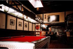 a pool table in a bar with a red cloth at Postmasburg hotel in Postmasburg