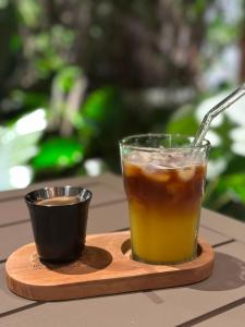 a cup of coffee and a drink on a wooden tray at Bali Atins in Atins