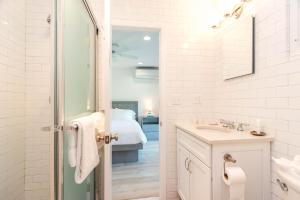 a white bathroom with a sink and a bed at The Ocean Dunes at Amagansett in Amagansett +201 photos