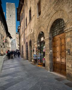 ulica z dużym budynkiem z drewnianymi drzwiami w obiekcie Affittacamere Chiti Melania w mieście San Gimignano