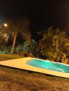 a swimming pool at night with palm trees at Cabaña La Churra in Corrientes +1 photo