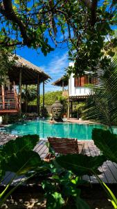 a swimming pool with two chairs and a building at Bali Atins in Atins