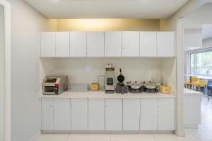 a white kitchen with white cabinets and appliances at TownePlace Suites by Marriott Boynton Beach in Boynton Beach