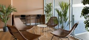 a group of chairs and tables in a room with plants at B&B HOTEL Lisboa Aeroporto in Lisbon