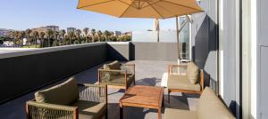 a balcony with chairs and a table and an umbrella at B&B HOTEL Lisboa Aeroporto in Lisbon