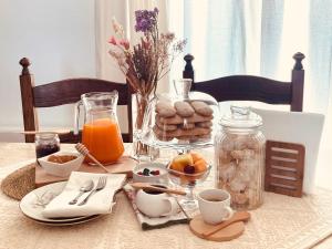 a table with a breakfast of eggs bread and orange juice at DomoMea Rooms in Loculi