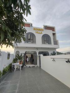 a large white building with people standing outside of it at Villa RonRoy Hà Tiên in Hà Tiên