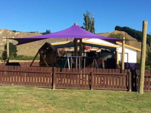 a purple umbrella on top of a wooden fence at Parikino School 