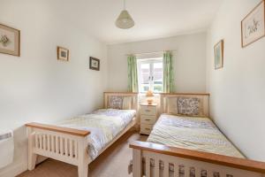 a twin bedroom with two beds and a window at 2 Bed in Warminster oc-52105 in West Knoyle