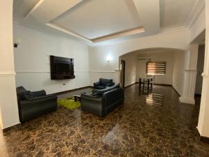 a living room with couches and a flat screen tv at Crispan Luxury Apartment in Jos +7 photos