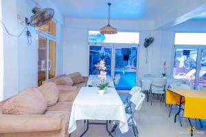 a living room with a couch and a table and chairs at La Reserve Hotel in Cap-Haïtien