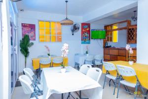 a dining room with white tables and white chairs at La Reserve Hotel in Cap-Haïtien