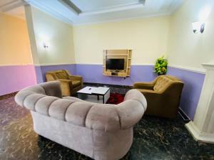 a living room with a couch and a tv at Crispan Luxury Apartment in Jos