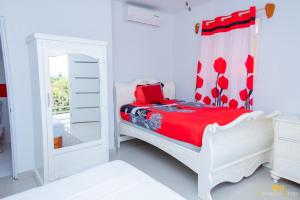a white bedroom with a bed and a mirror at La Reserve Hotel in Cap-Haïtien +25 photos