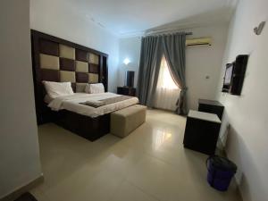 a bedroom with a large bed and a window at Crispan Luxury Apartment in Jos