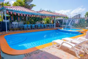 a swimming pool with two chairs and a fountain at La Reserve Hotel in Cap-Haïtien