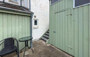 a green garage with a table next to a door at Nice Apartment In Hanstholm With Wifi in Hanstholm +7 photos