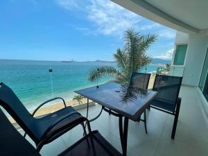 ein Balkon mit Tisch und Stühlen und dem Meer in der Unterkunft Condominio Marlica in Manzanillo