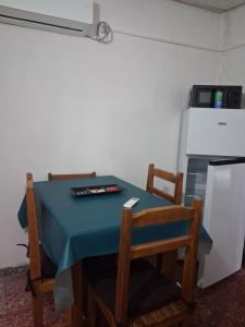 a blue table with two chairs and a refrigerator at Apto centrico in Dolores
