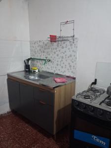 a small kitchen with a stove and a sink at Apto centrico in Dolores