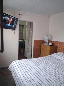 a bedroom with a bed and a tv on the wall at Apto centrico in Dolores