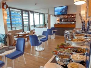 a restaurant with a buffet of food on a table at Guest Favorite Sea View Apartments Batumi in Batumi