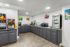 a large kitchen with gray cabinets and appliances at Quality Inn & Suites Ridgeland in Ridgeland